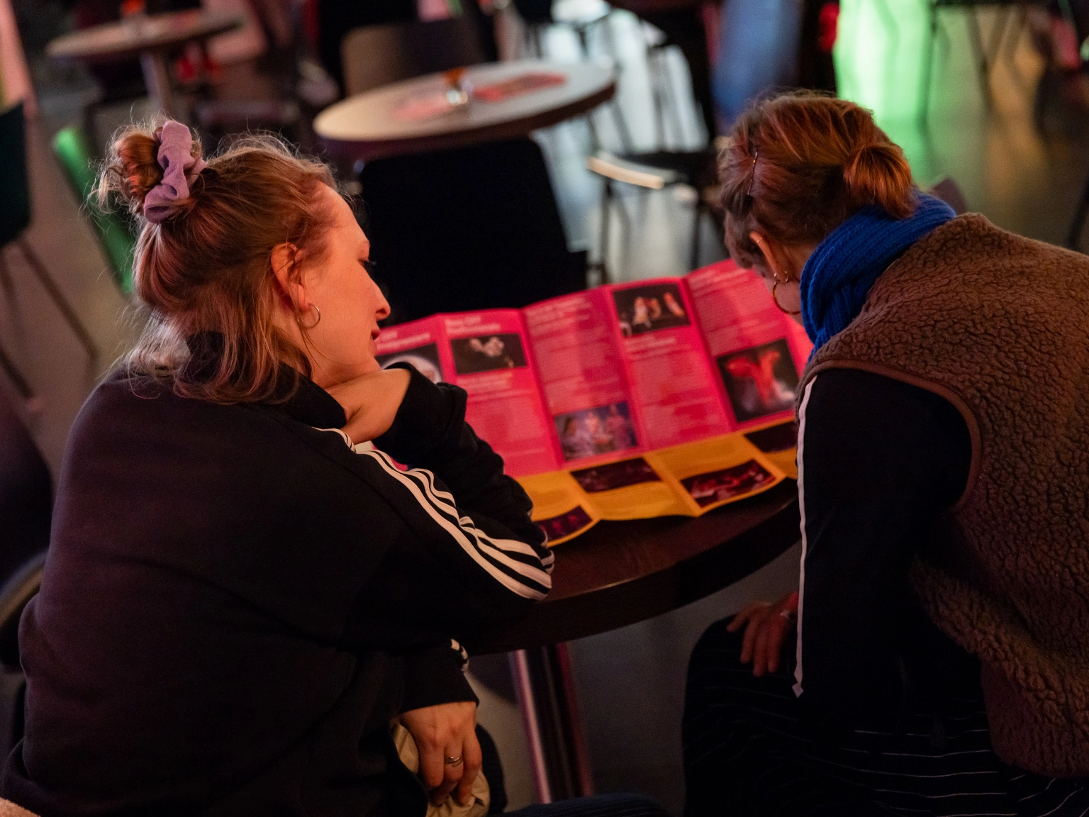 Impression des Best OFF Festivals Freier Theater: Besucher*innen lesen im Programmflyer